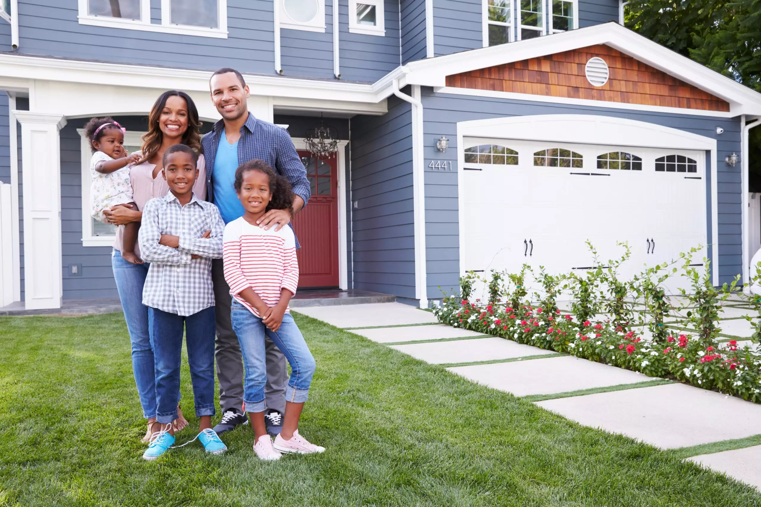 Happy family in front of new home